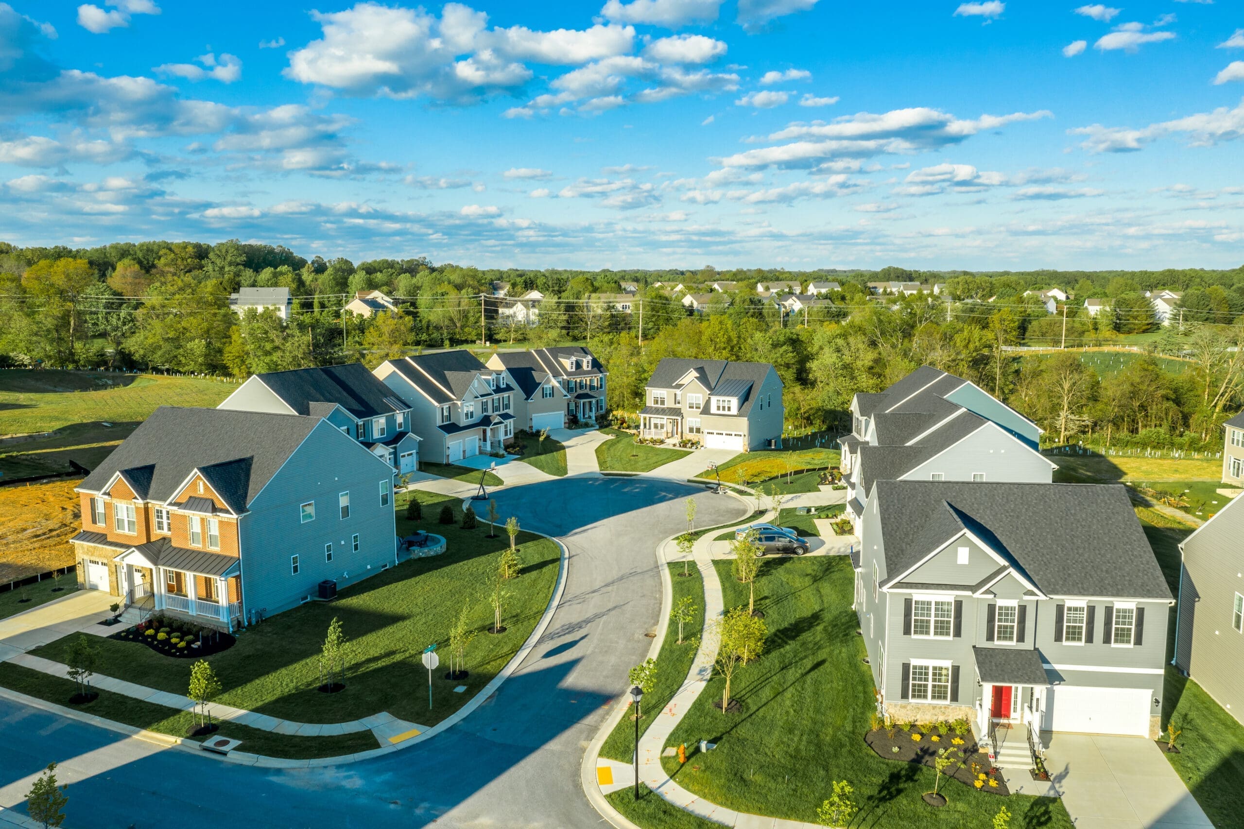 Aerial view of dead end street with residential single family luxury homes in the East Coast USA with blue cloudy sky